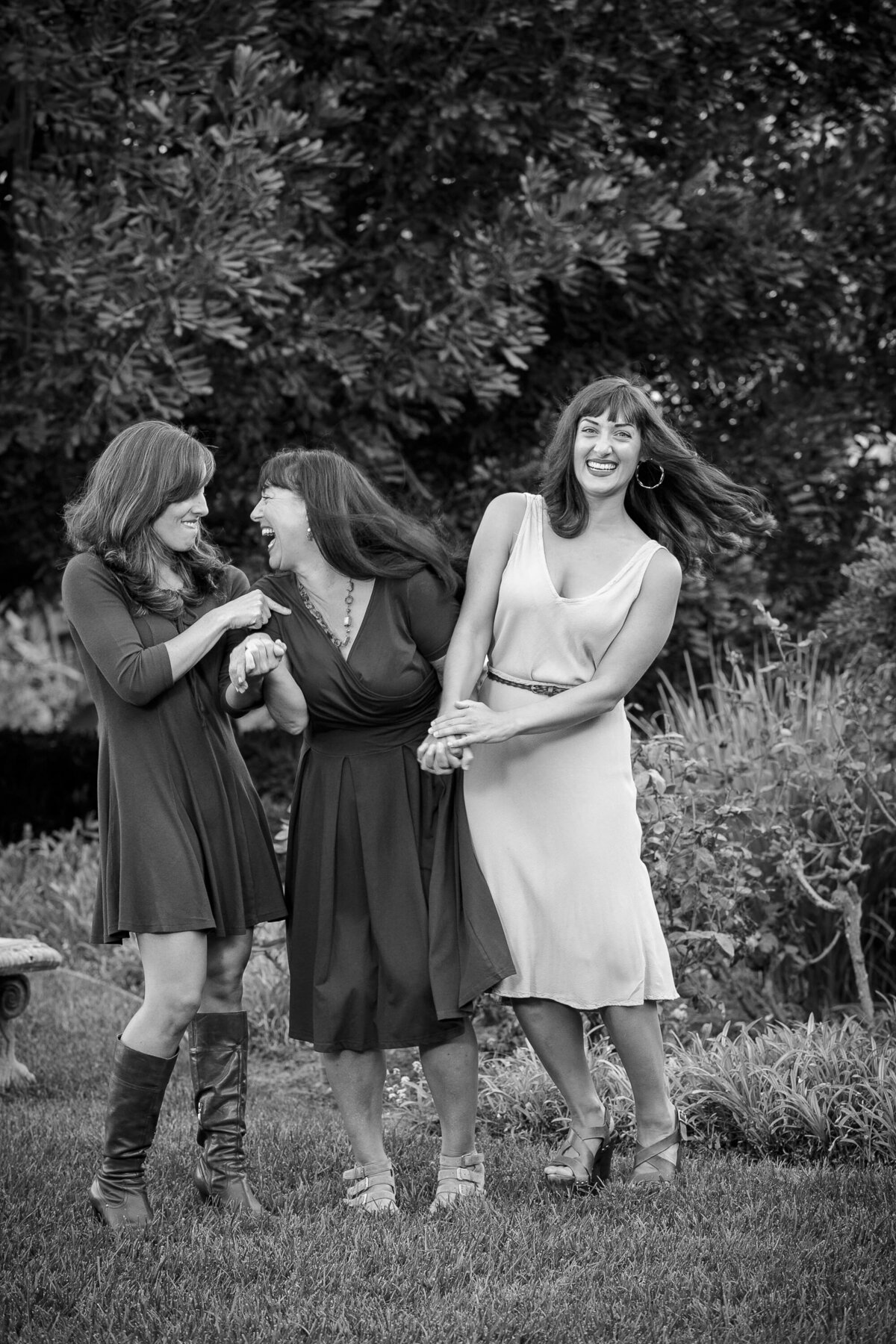 Three women holding hands and laughing