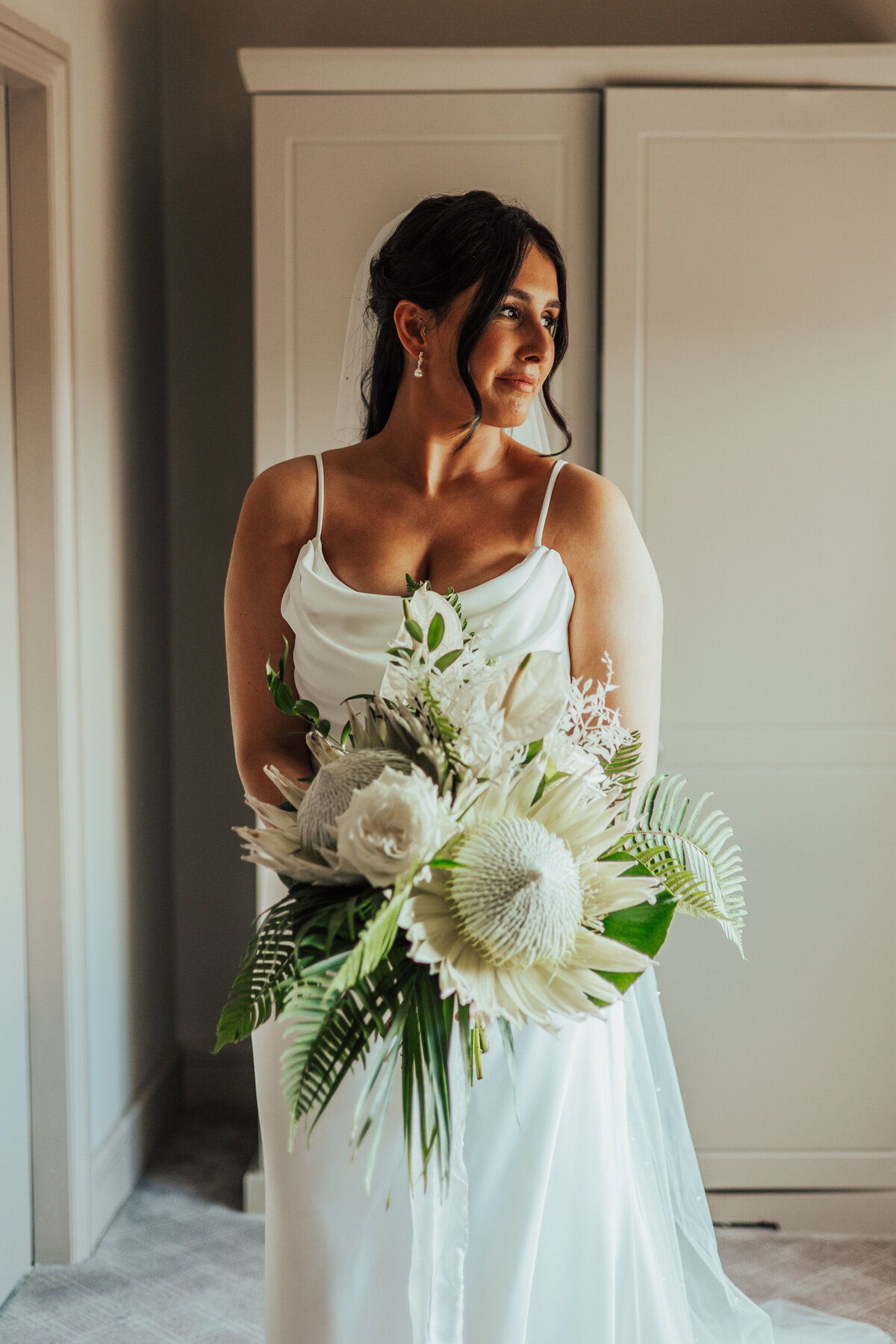 bride with white protea bouquet