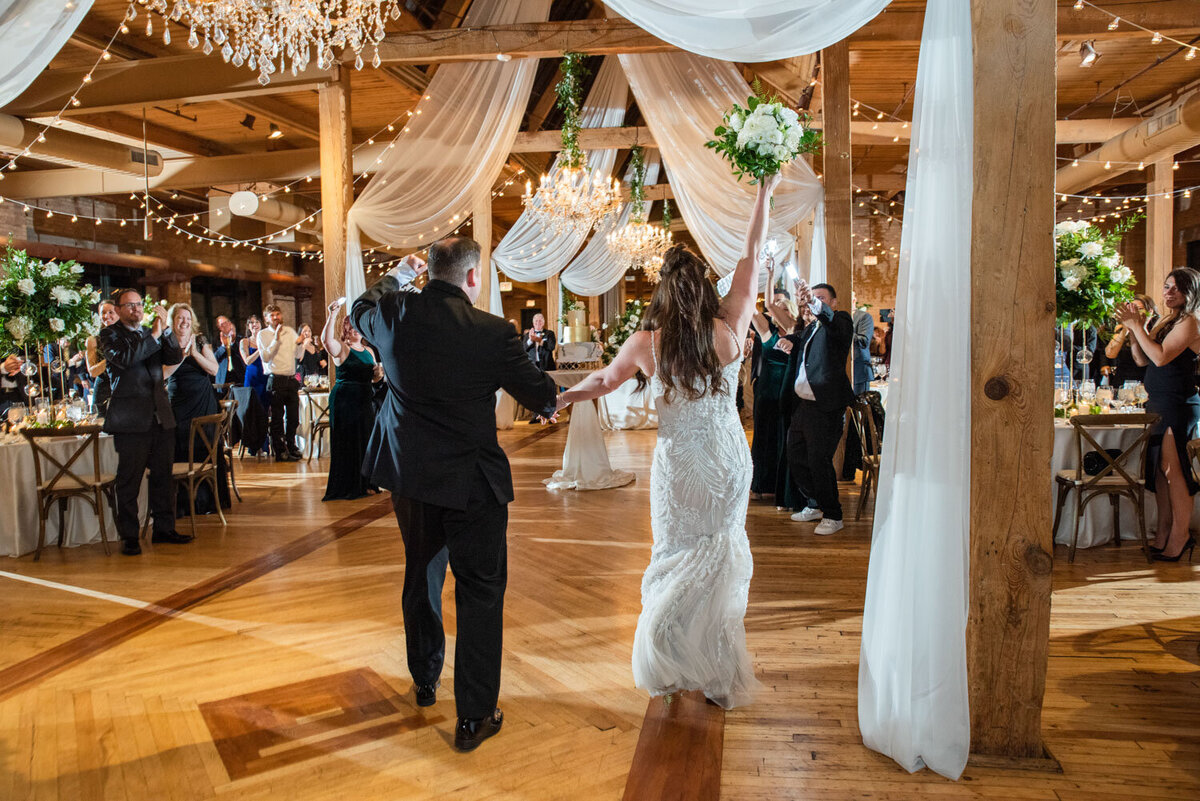 A bride and groom are dancing at their wedding reception
