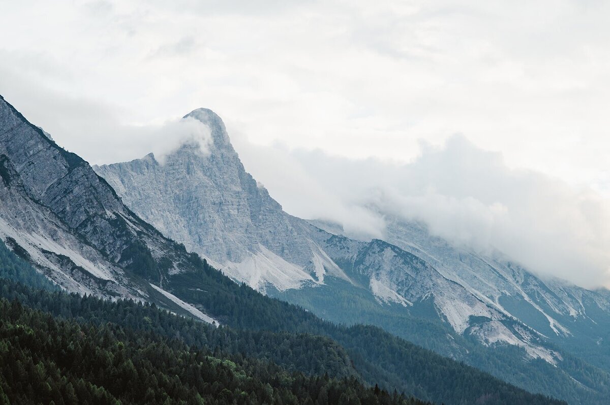 The Red Mountain of Silverton and Ouray, Colorado rises out of the green forest landscape.