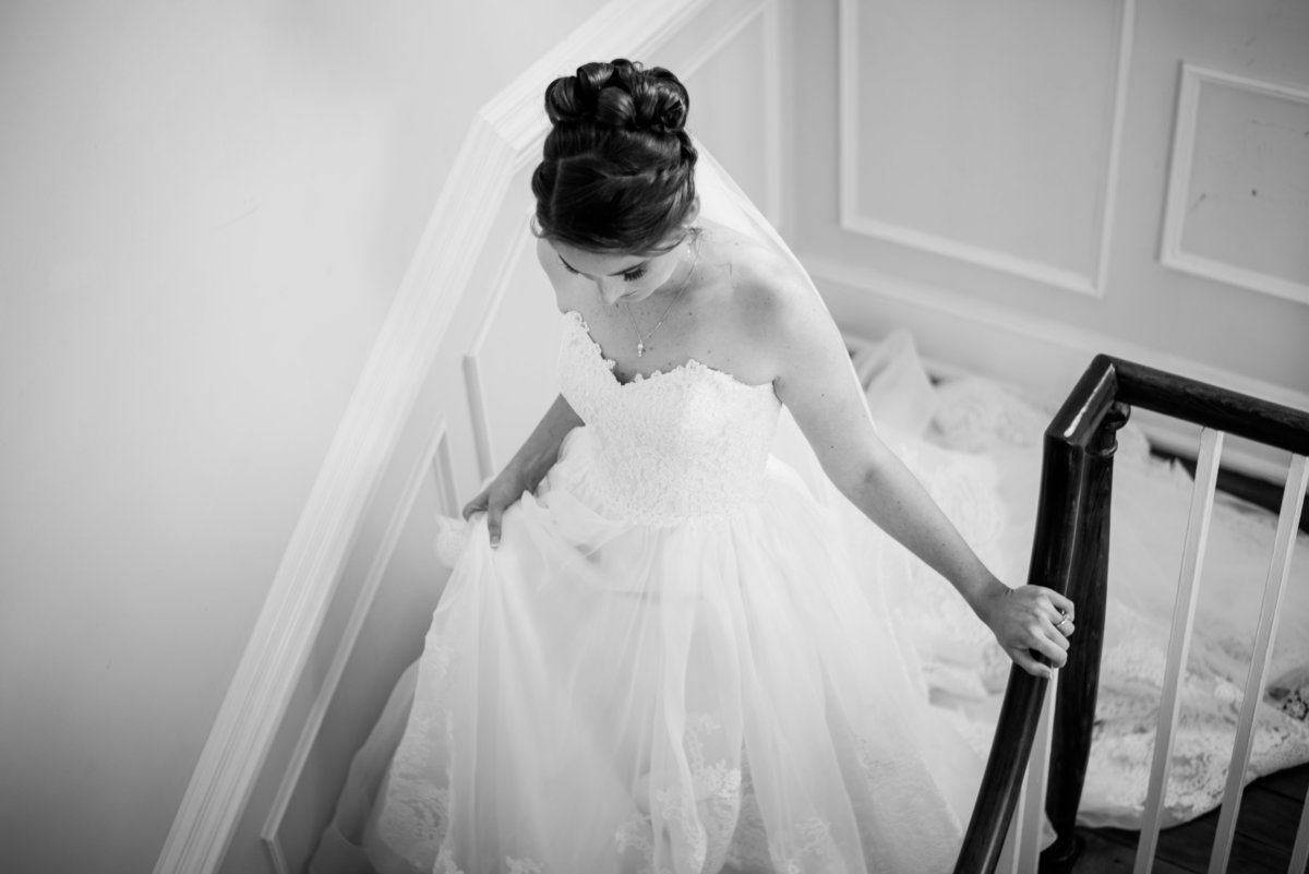bride walking down stairs at estate at white hall vineyard wedding by virignia wedding photographer