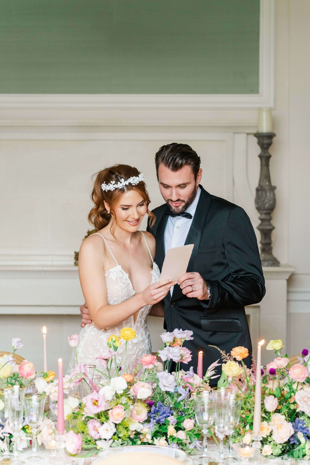 bride and groom looking at their menus behind a table  with flowers