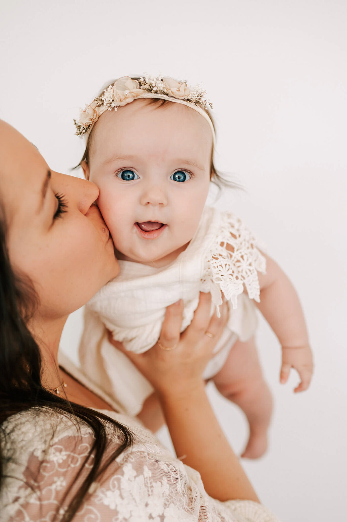 mom kissing smiling baby during Branson MO family photography session