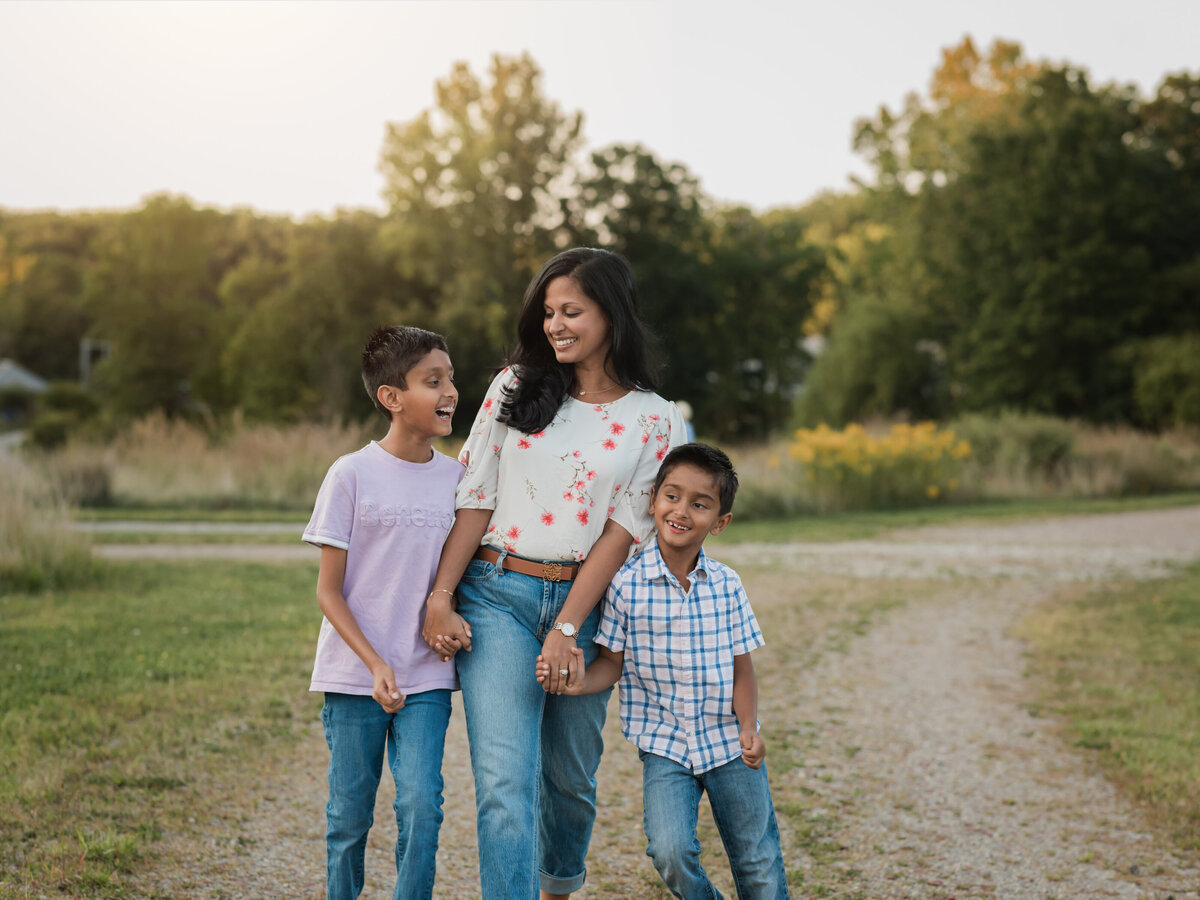 mom and two sons walking in park for family photos 
