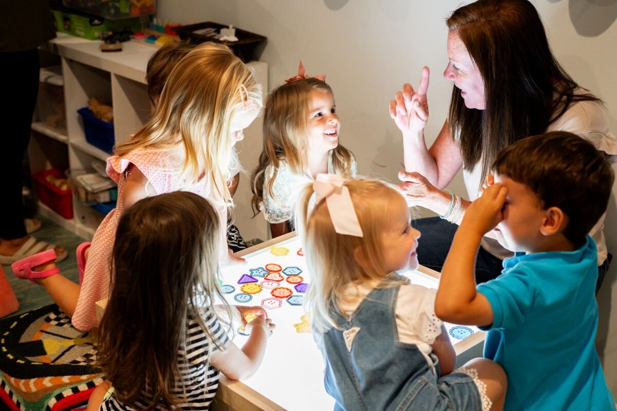 Ms. Jackie showing students how to learn and play using the light up board in the classroom at The Nest, a preschool and learning center in Surf City, North Carolina
