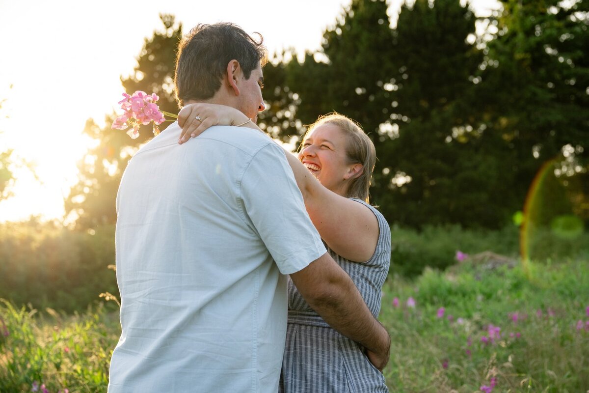 engaged couple in wildflowers at discovery park seattle