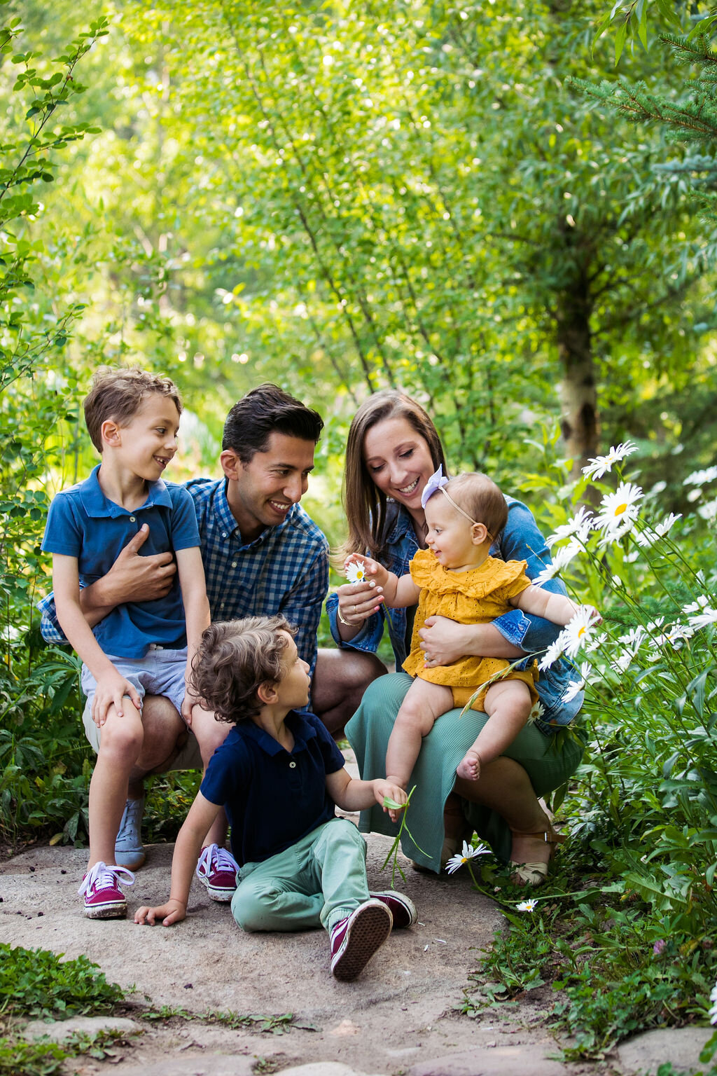 Two parents sit outdoors with their three children.