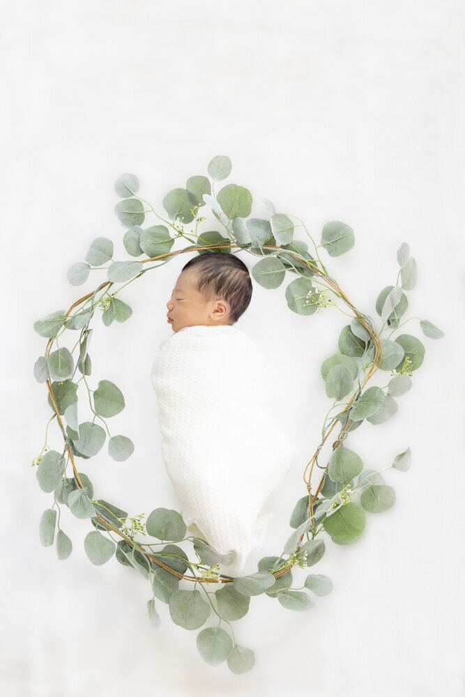 baby boy in eucalyptus leaves