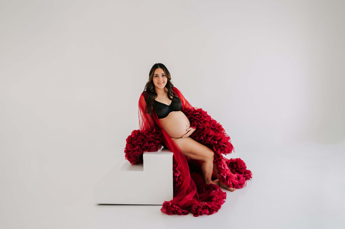 maternity photo in Branson of pregnant mom sitting on stairs in red robe