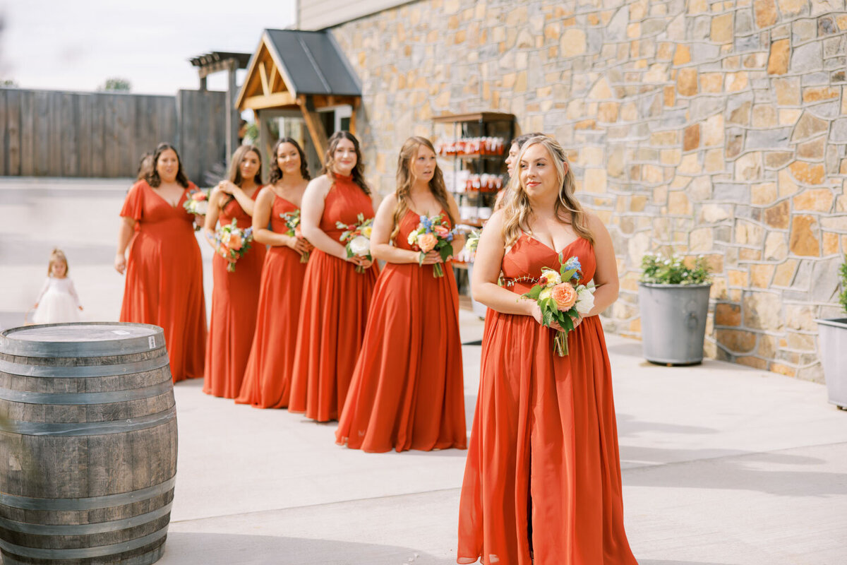 Bridesmaids in matching red dress holding their bouquet