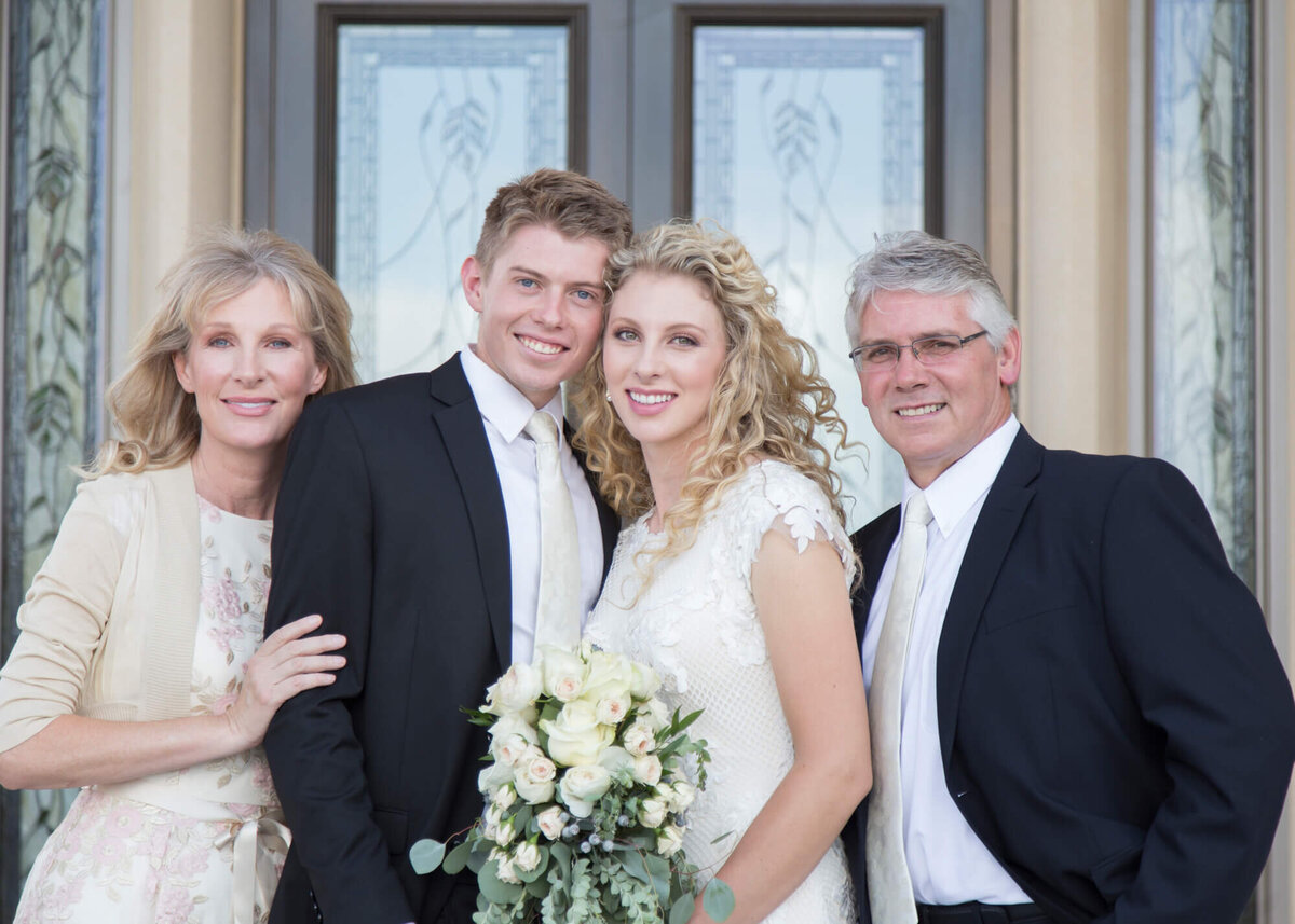 a wedding couple and parents on a sunny wedding day