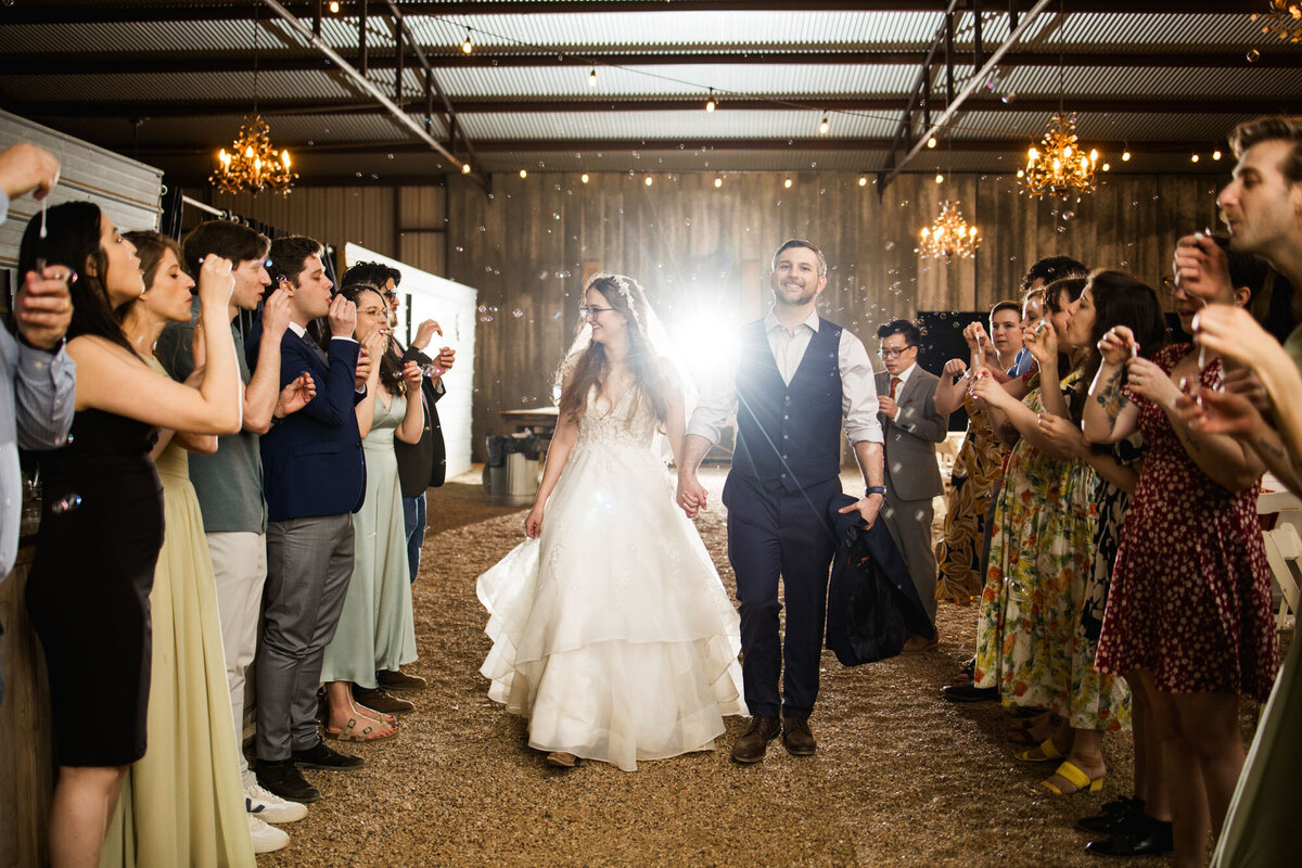 Couple walking through indoor sparkler exit with guests