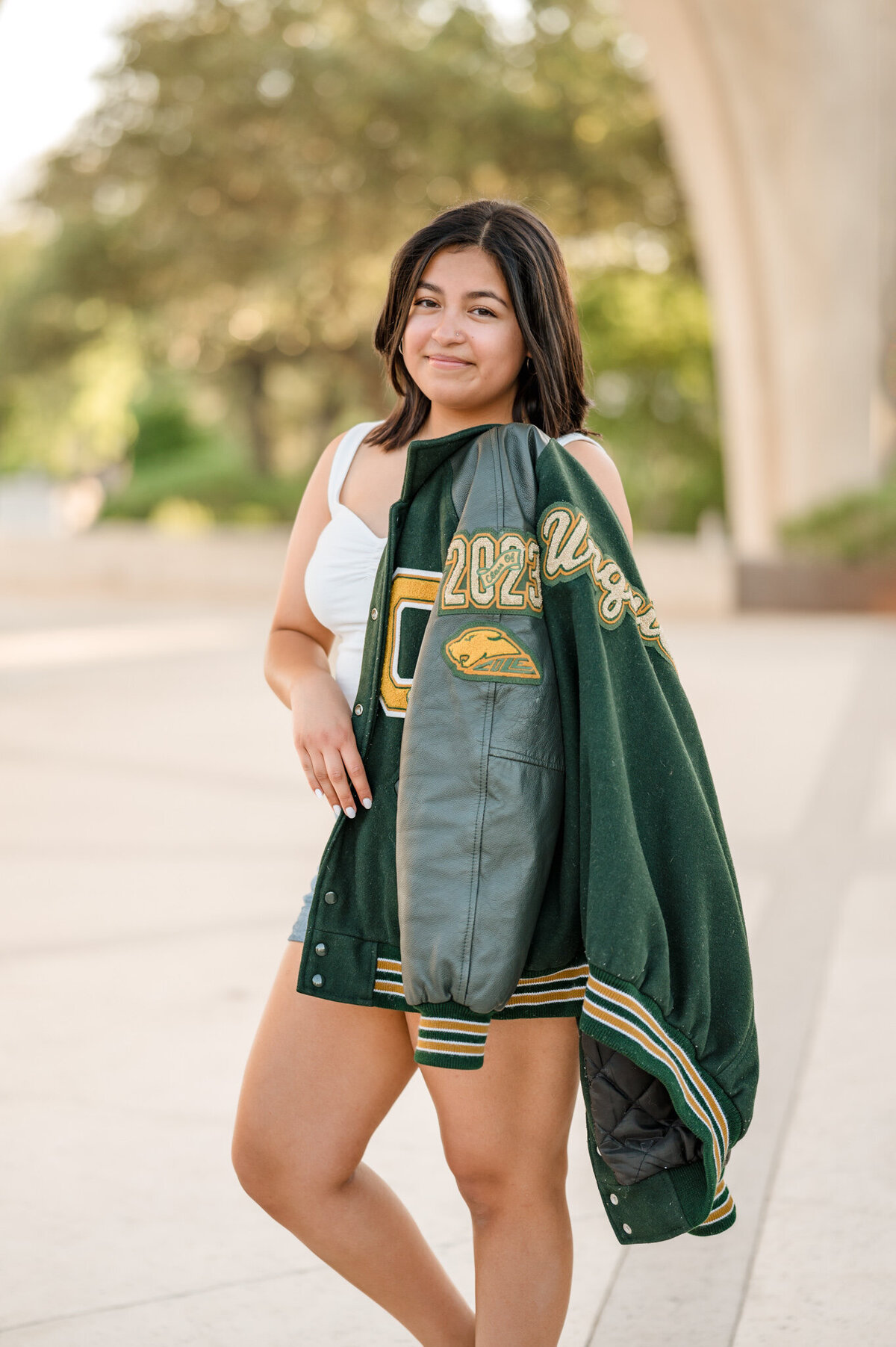Senior poses with her letterman jacket during pictures.