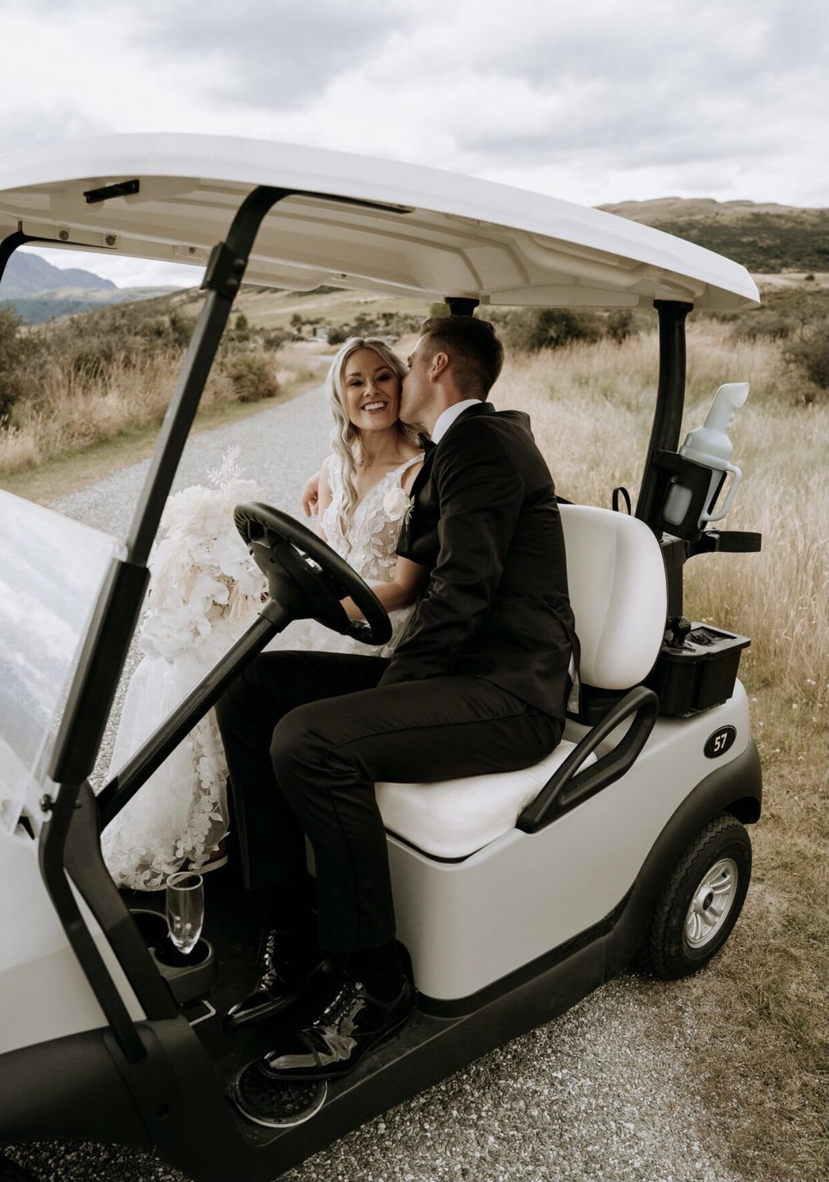 golfcart-brideandgroom-kissing-queenstown-jackspoint