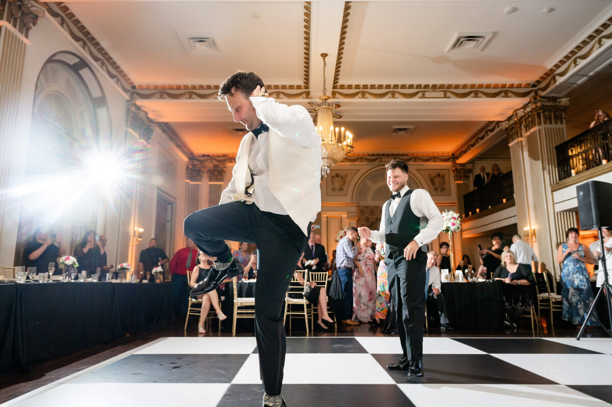 black and white checkered dance floor in george washington hotel with groom dancing fun
