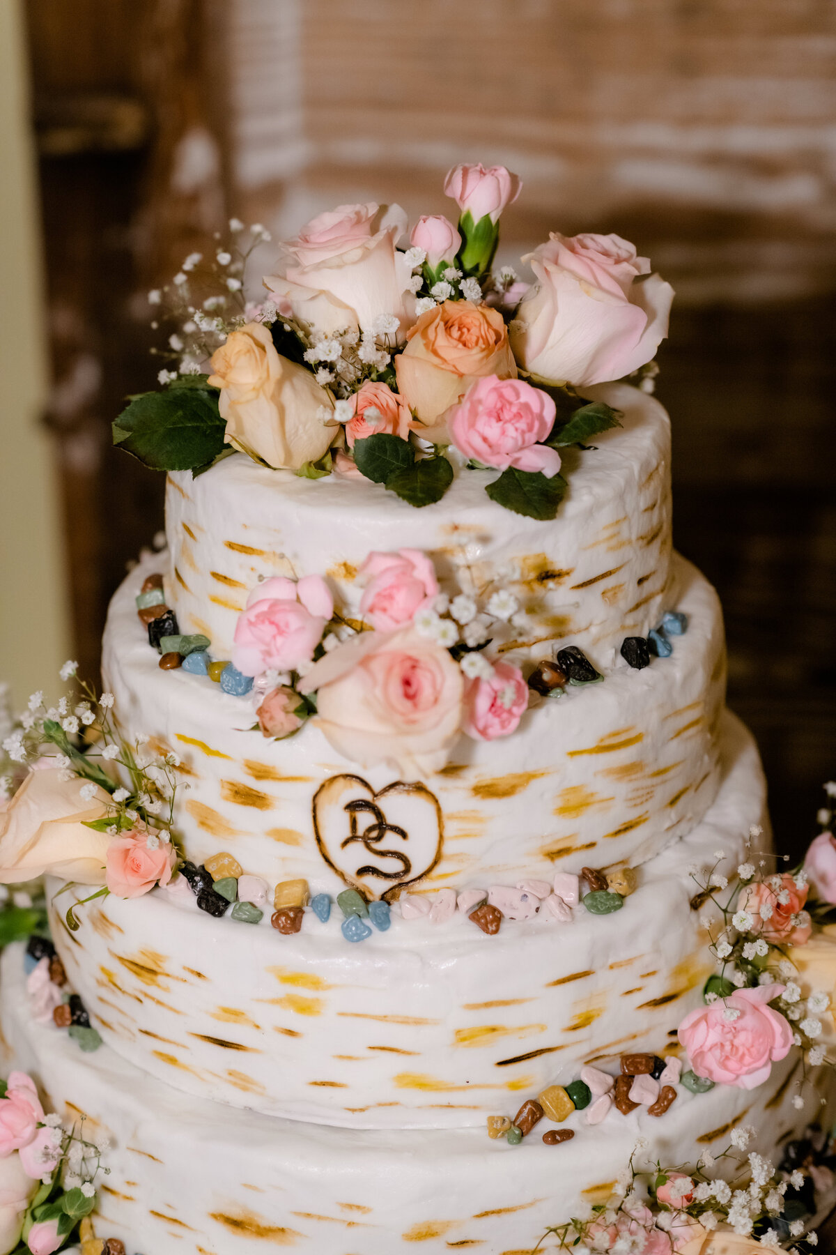rustic wedding cake with pink florals and small blue details