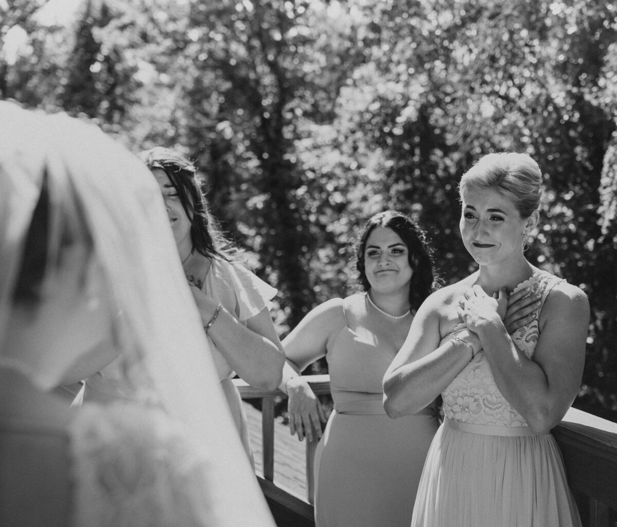 Bridesmaids watching the wedding ceremony, one with tears in her eyes