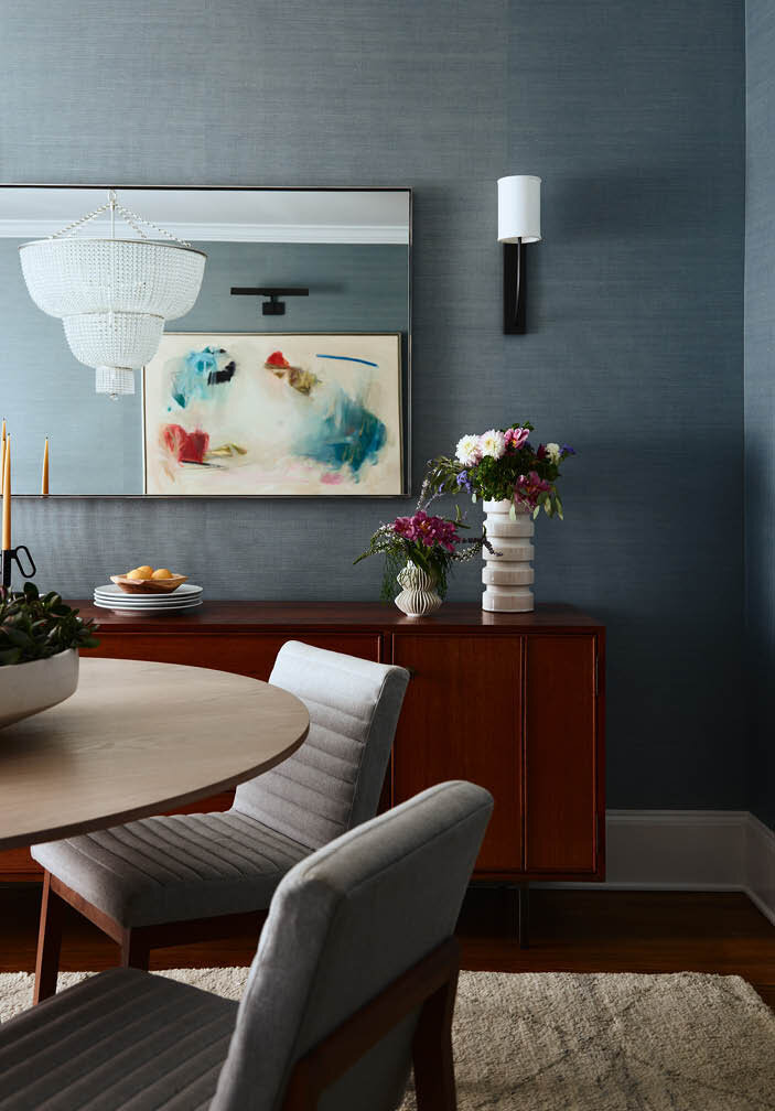 Explore the dining room featuring dark blue grasscloth wallcovering, a cerused oak dining table, and a walnut console, blending sophistication and timeless style.