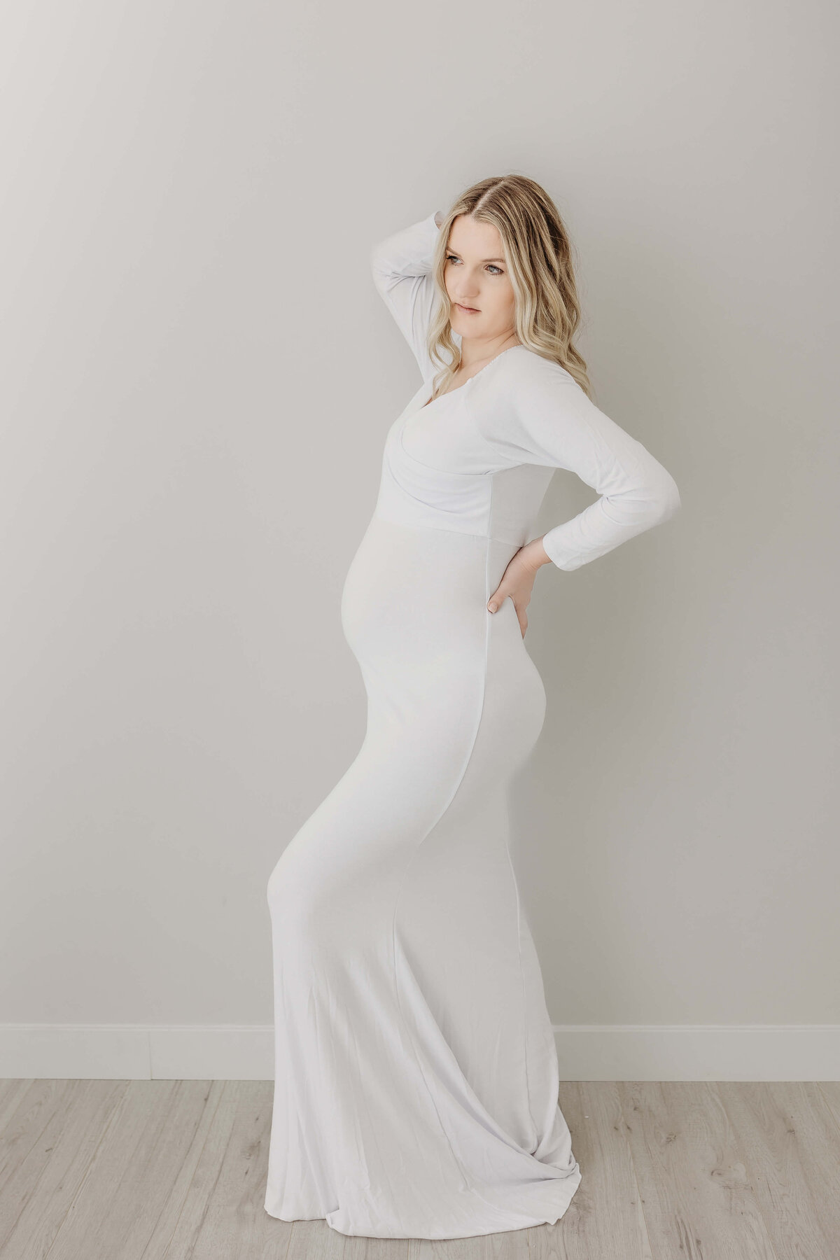 Mom in full white gown and posing pregnant