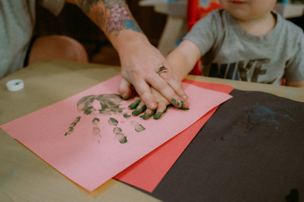mother and son's hands contributing to a painting project