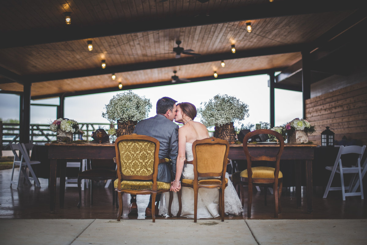 bride and groom kissing at the table at Hye Meadow Winery taken by Expose The Heart photography