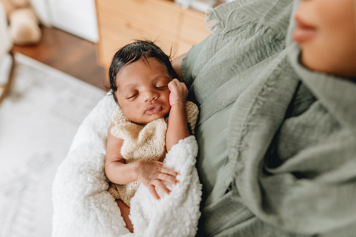 Newborn photography with a mom snuggles newborn