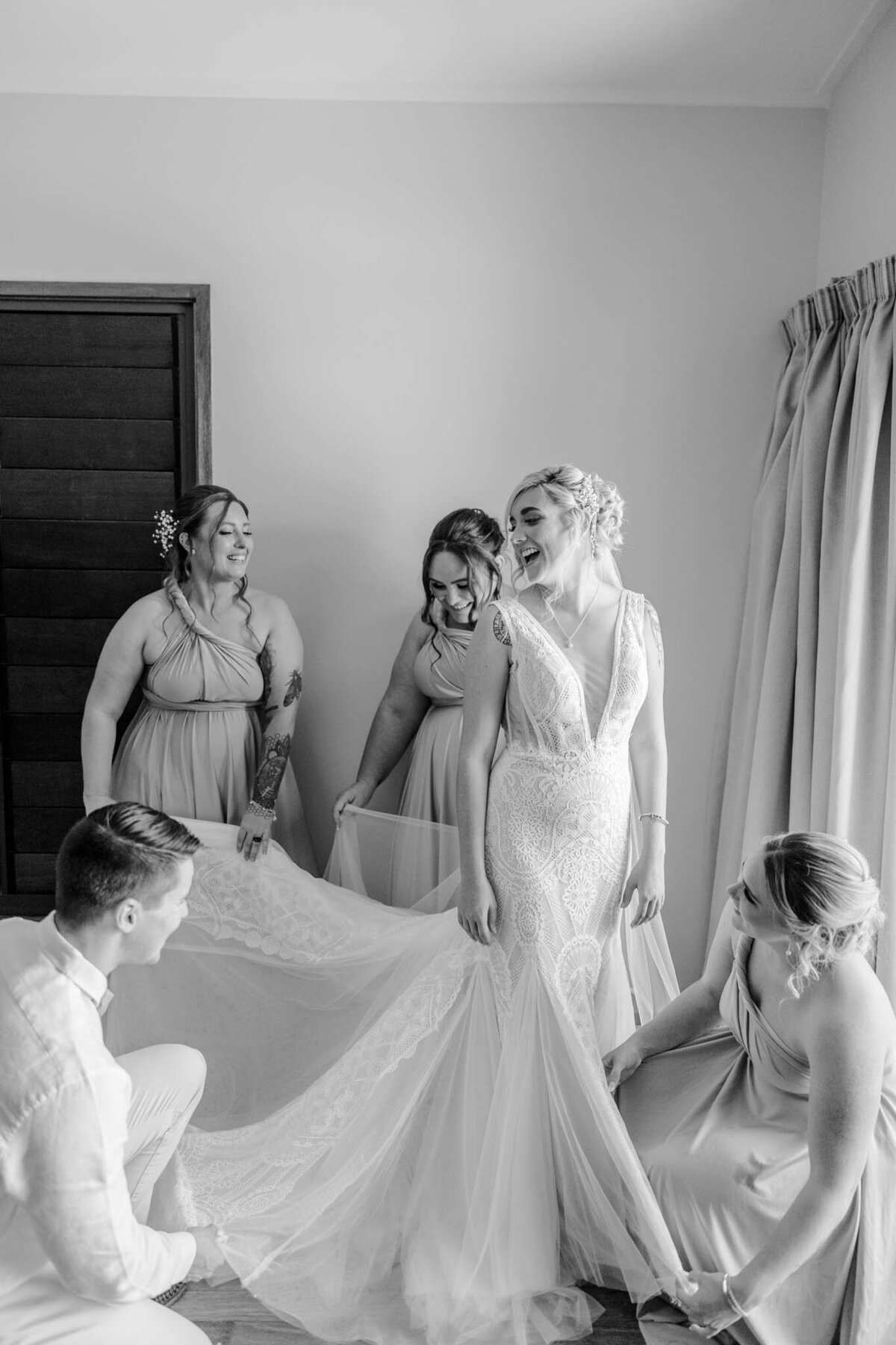 bridal party help bride get ready in her bridal suite on her wedding day