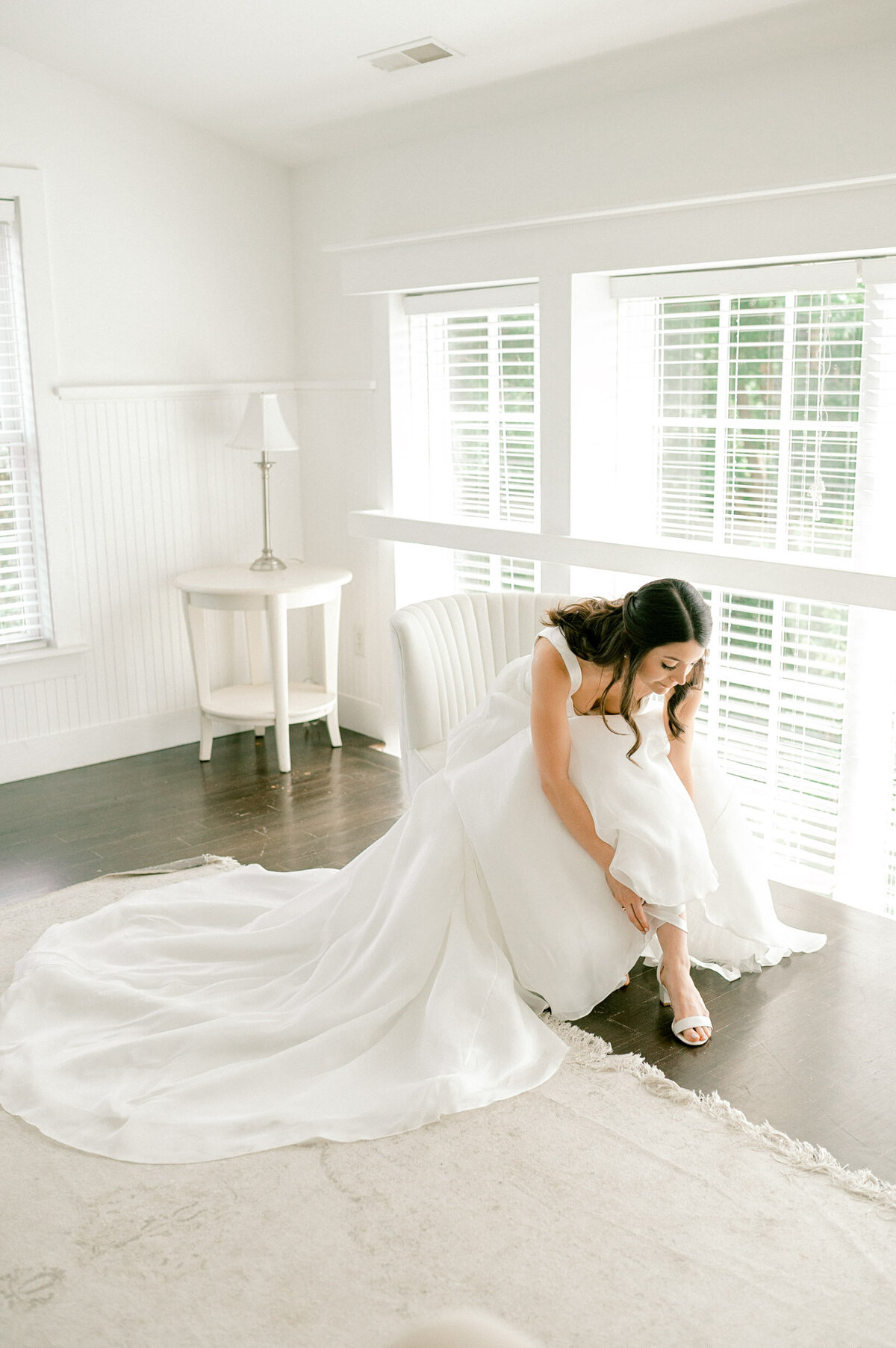 Bride putting on shoes in the bridal suite of Veritas Winery