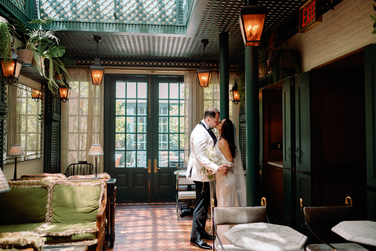 Bride and groom sharing a kiss inside Hotel Chelsea in New York City, captured during Japna and Chris’s intimate elopement by NYC wedding photographer Perry Hancock.