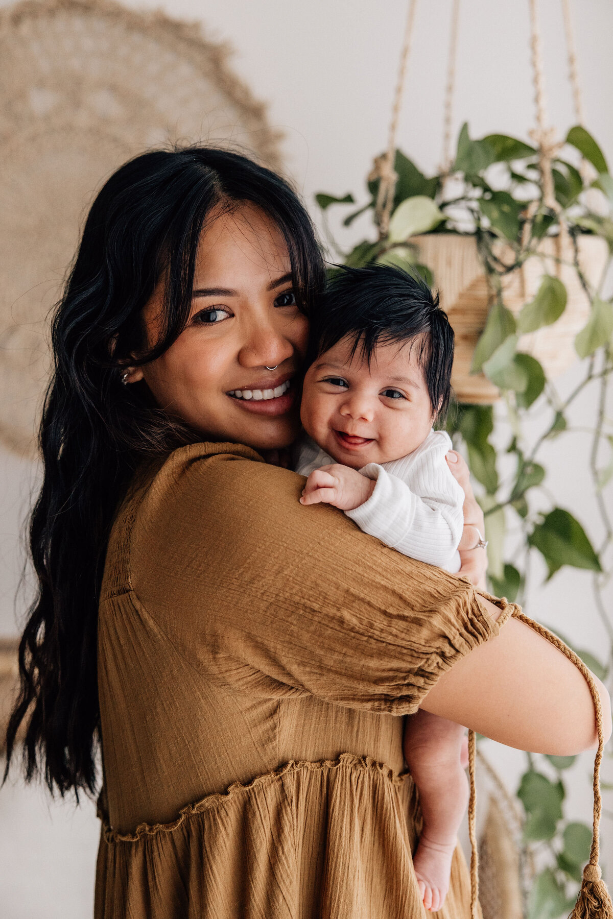Mum holds smiling baby over her shoulder
