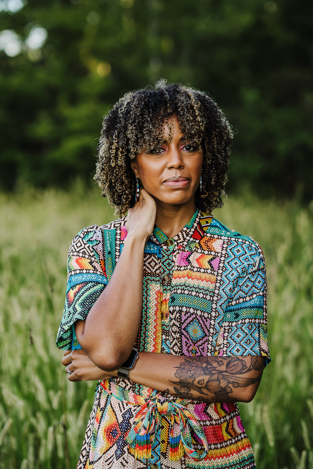 woman in tribal print takes headshots in a field in boston