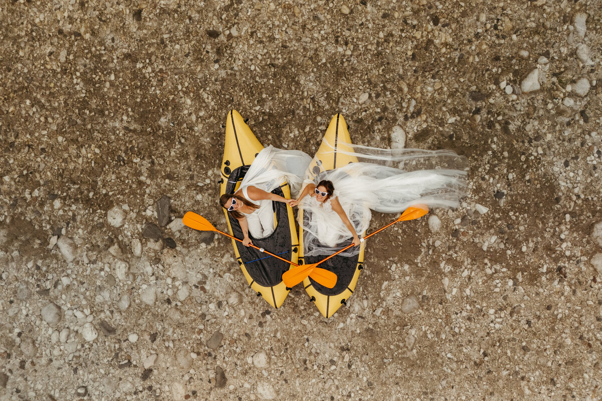 Aerial view of brides in yellow packraft in Soča Valley river elopement