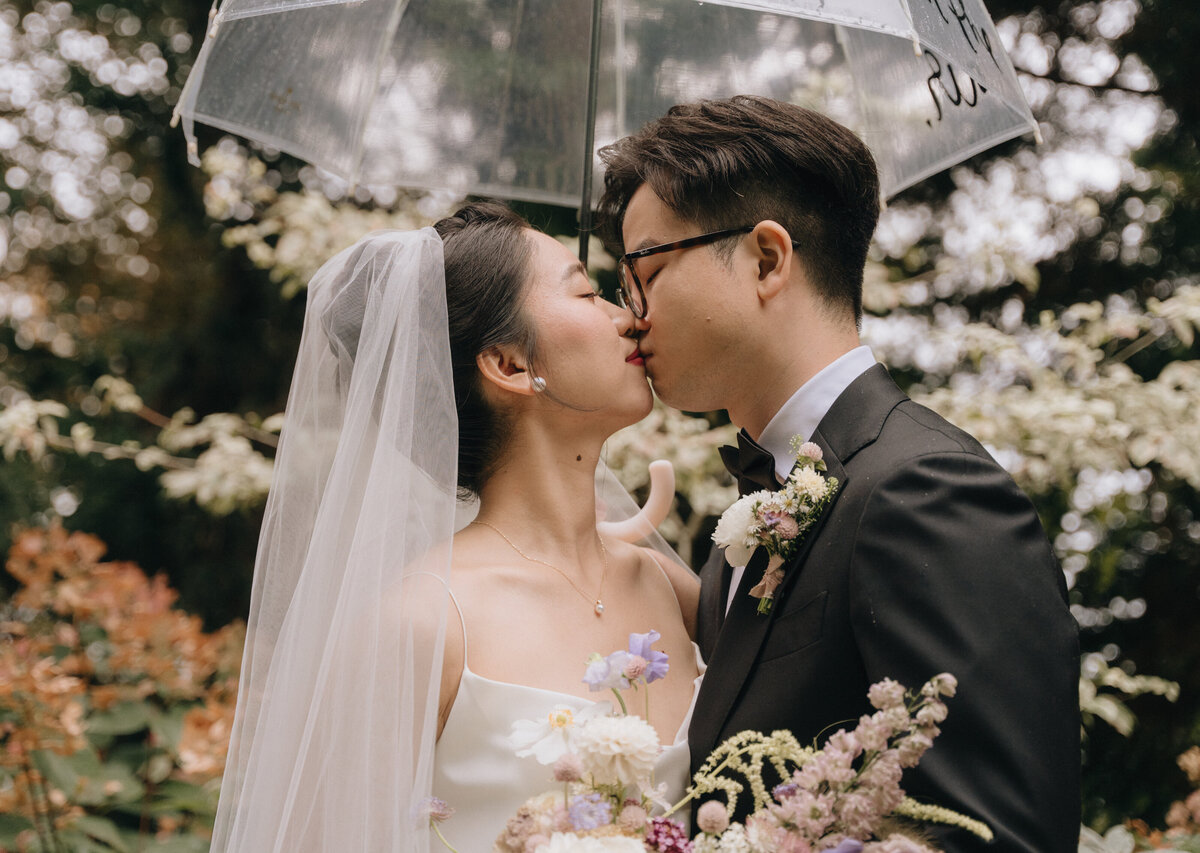 Couple kissing under an umbrella at JM Cellars Wedding