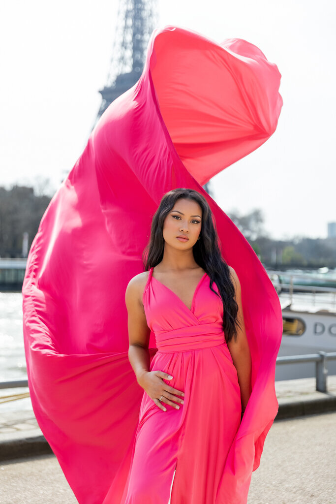 Fashion forward flying dress portrait with model in fuchsia gown creating dramatic movement