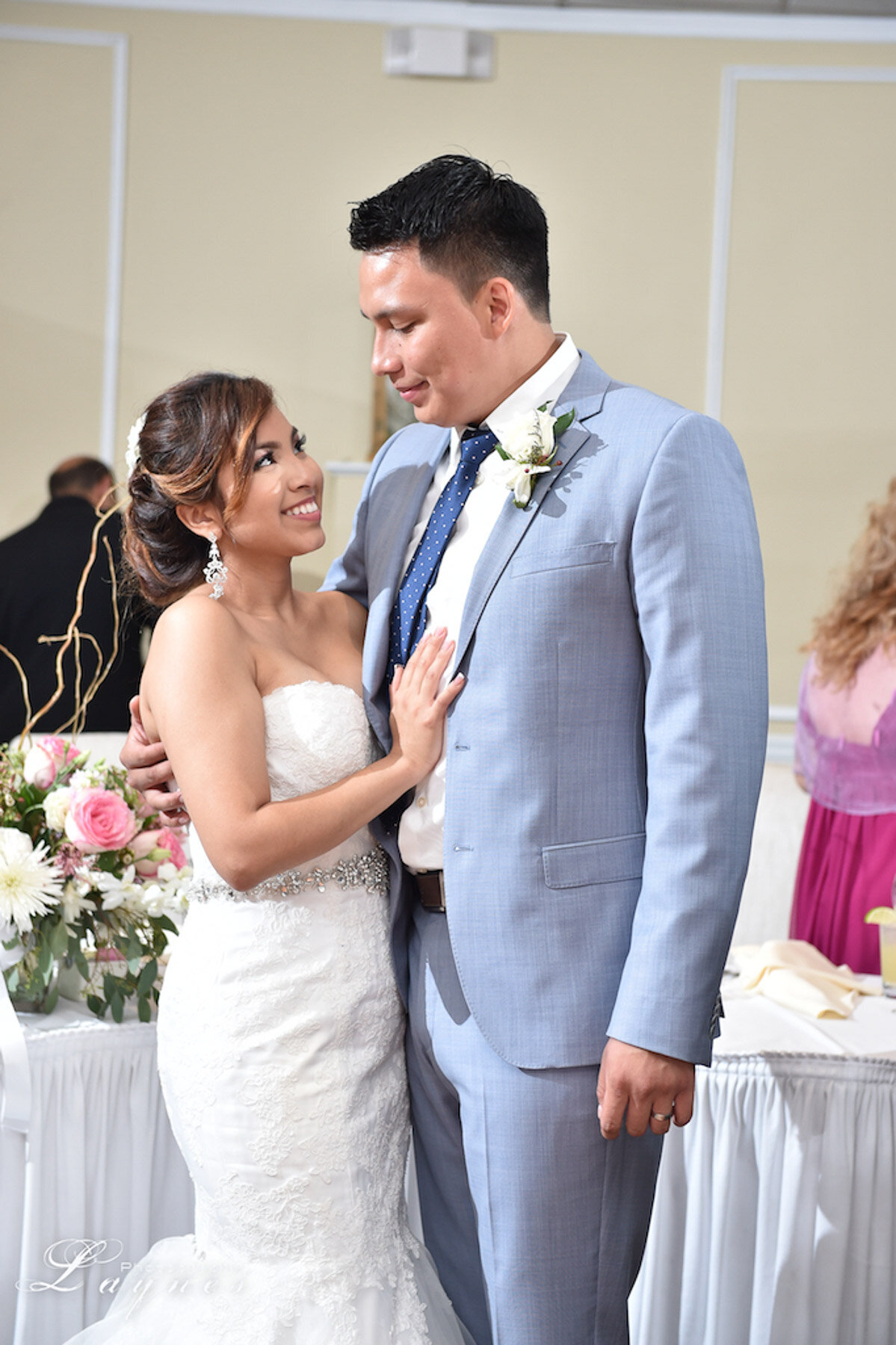 Bride and groom sharing a moment; soft glam bridal look with lashes and blush tones.