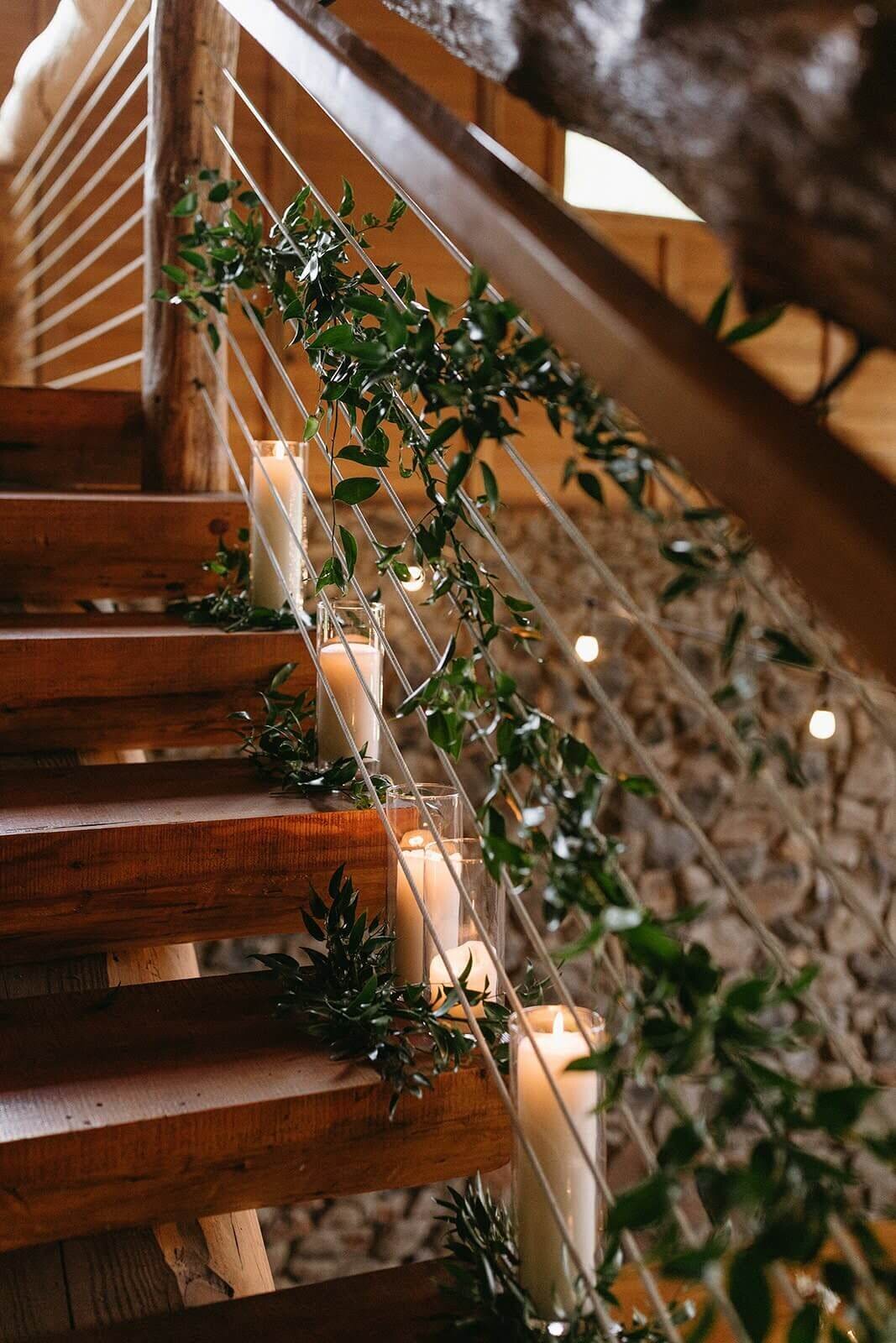 Greenery is woven along a staircase with candles for the bride's entrance at Maysara Winery.