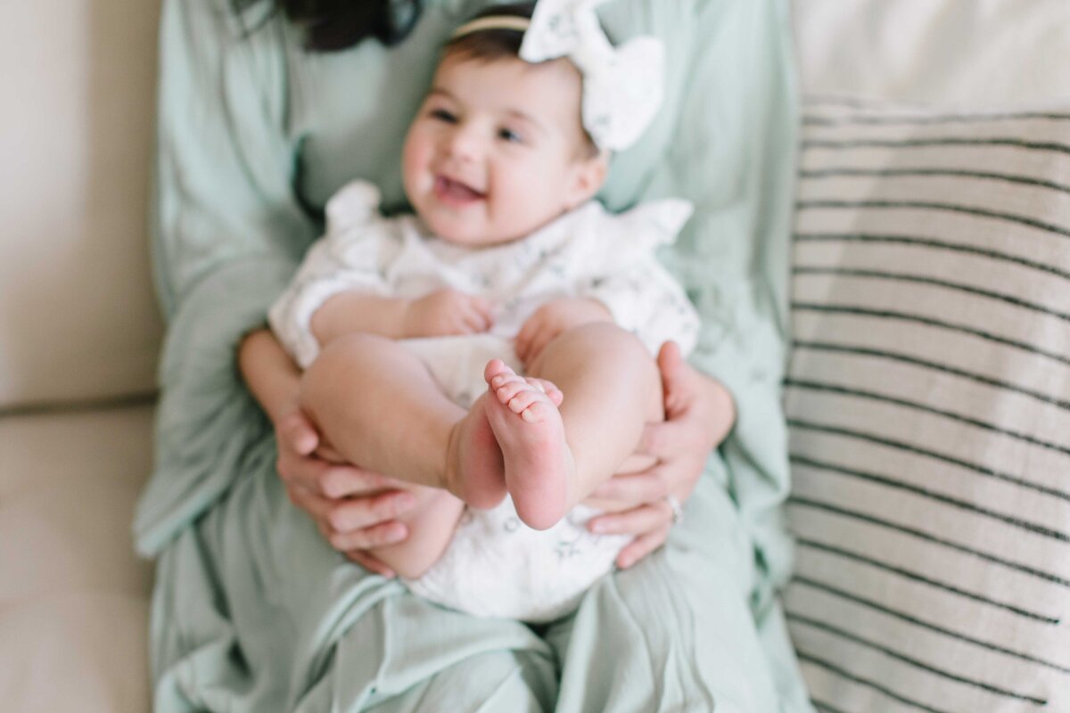 baby on moms lap with toes in the air