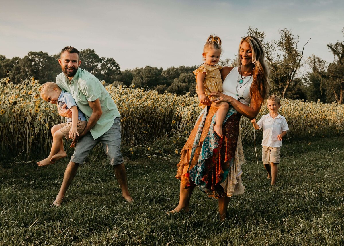 A Pittsburgh family is playing in a field of sunflowers.