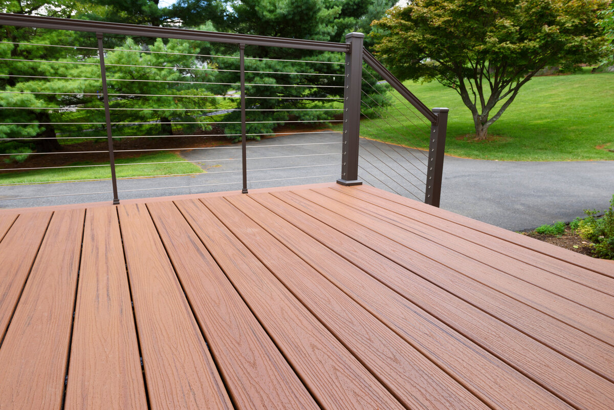 A natural stained deck with brown railings and wire supports built by a Worcester Deck Builder