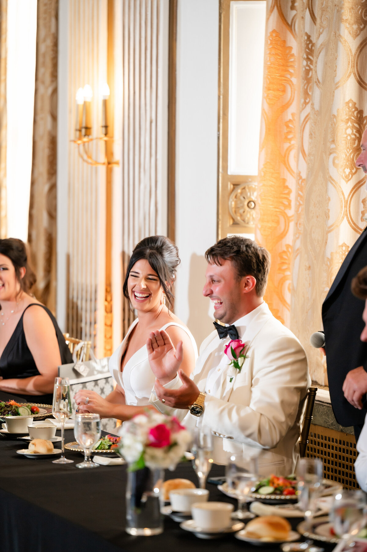 groom and bride laughing at speeches while sitting at their head table during reception at george washington hotel pennsylvania