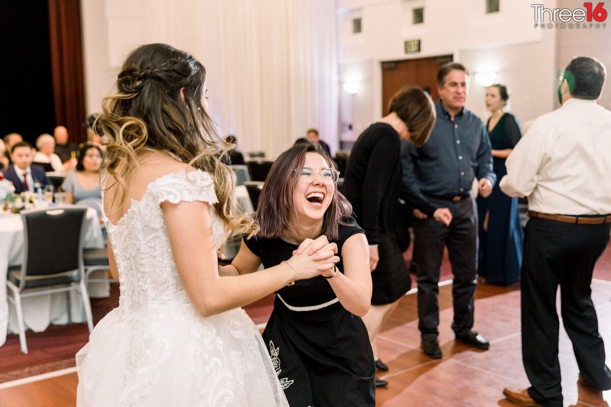 Laughing guest dances with the bride during the reception