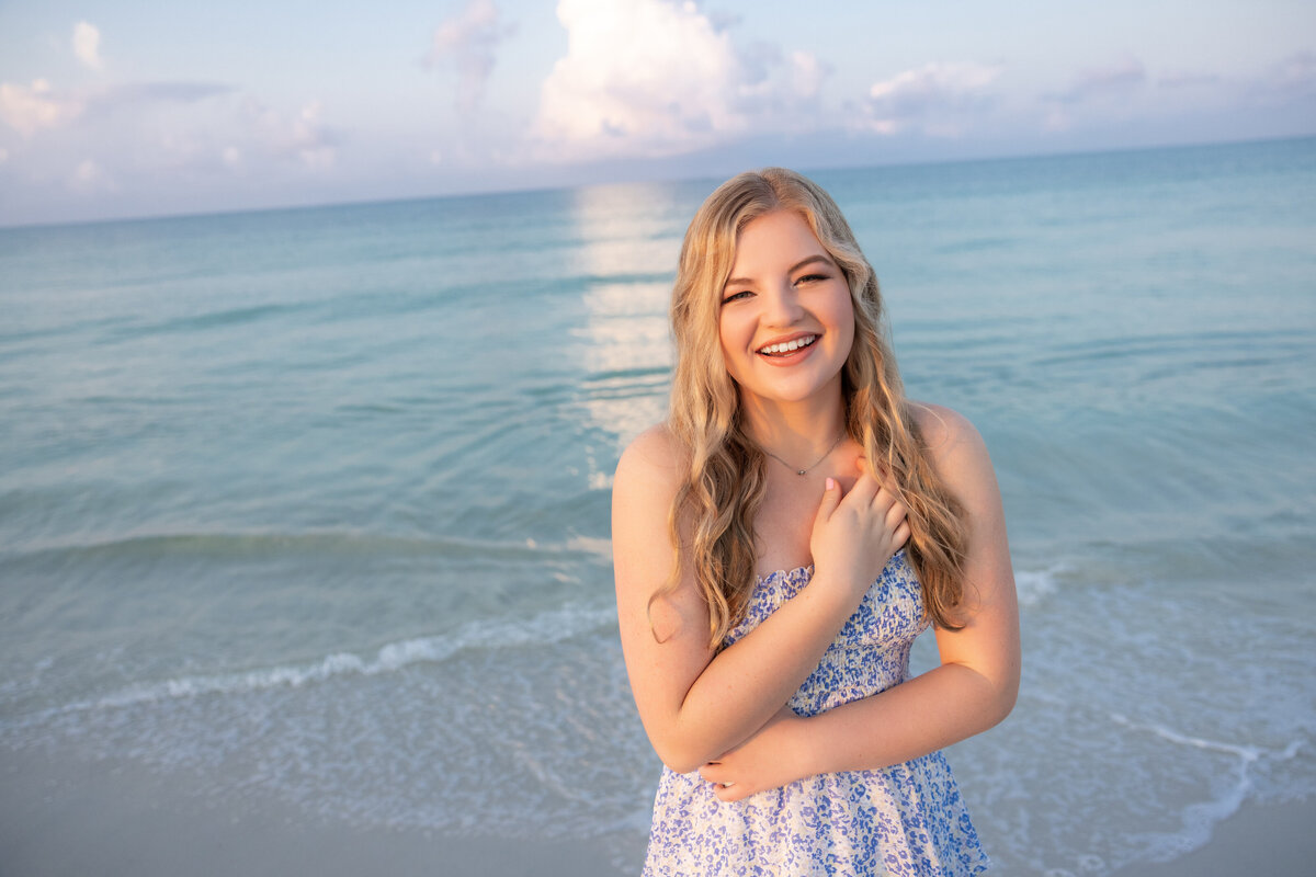 A girl laughing while standing at the beach