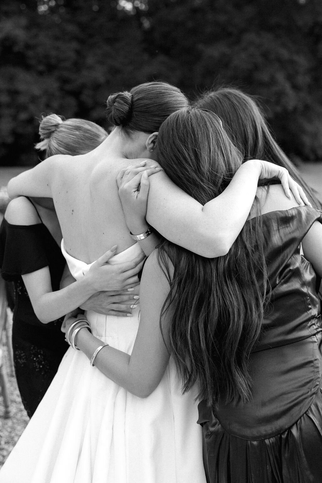 candid photo of bridesmaids hugging bride during the reception 