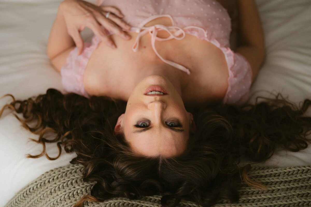 Colorado Springs Boudoir Photographer woman lying on bed looking up