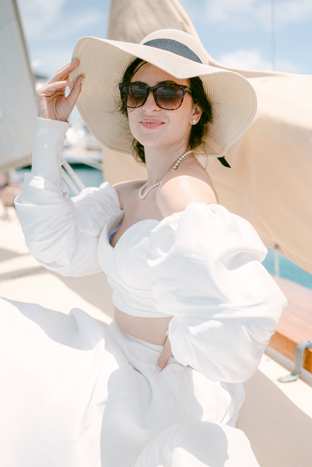 Bride wearing sunglasses and holding sunhat