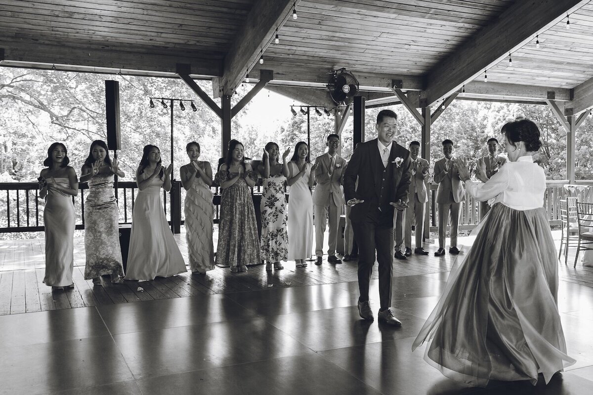 Bride and groom celebrating with guests on dance floor at reception