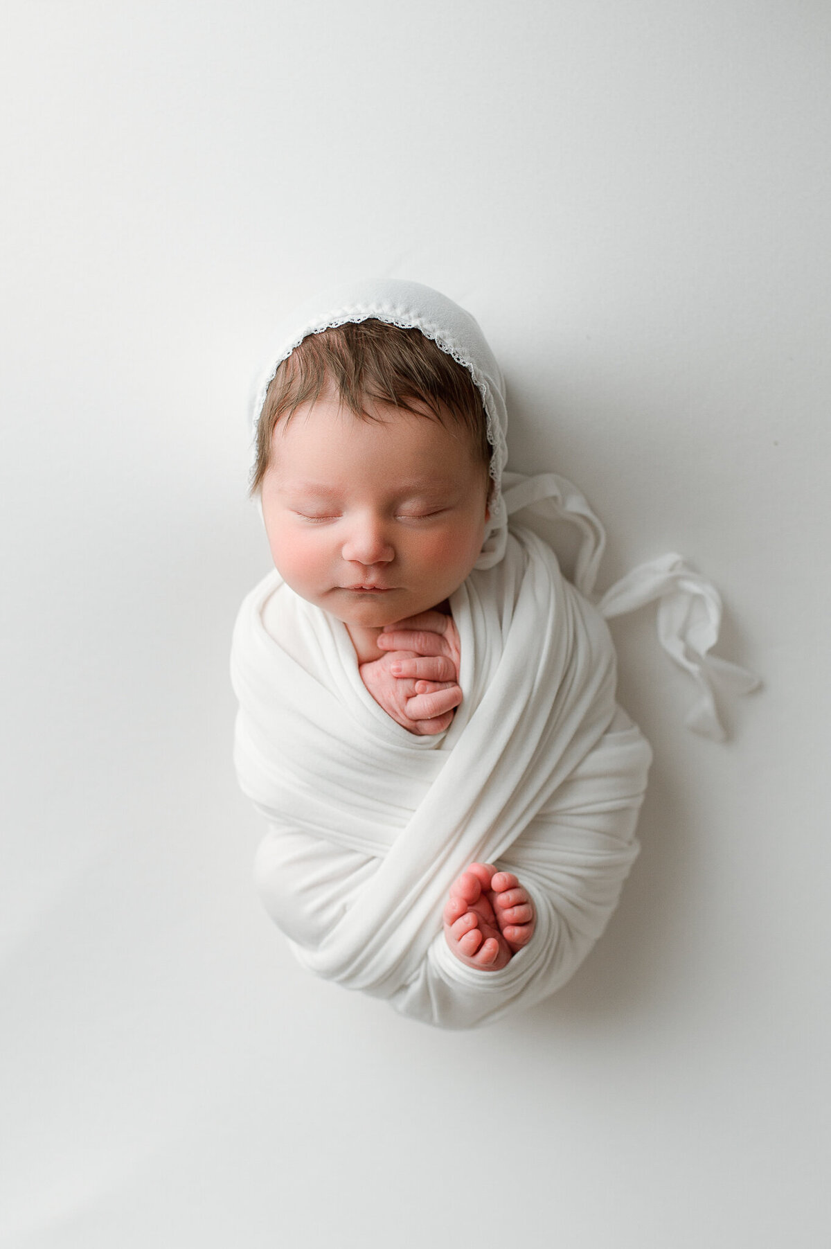 Newborn with toes poking out of swaddle