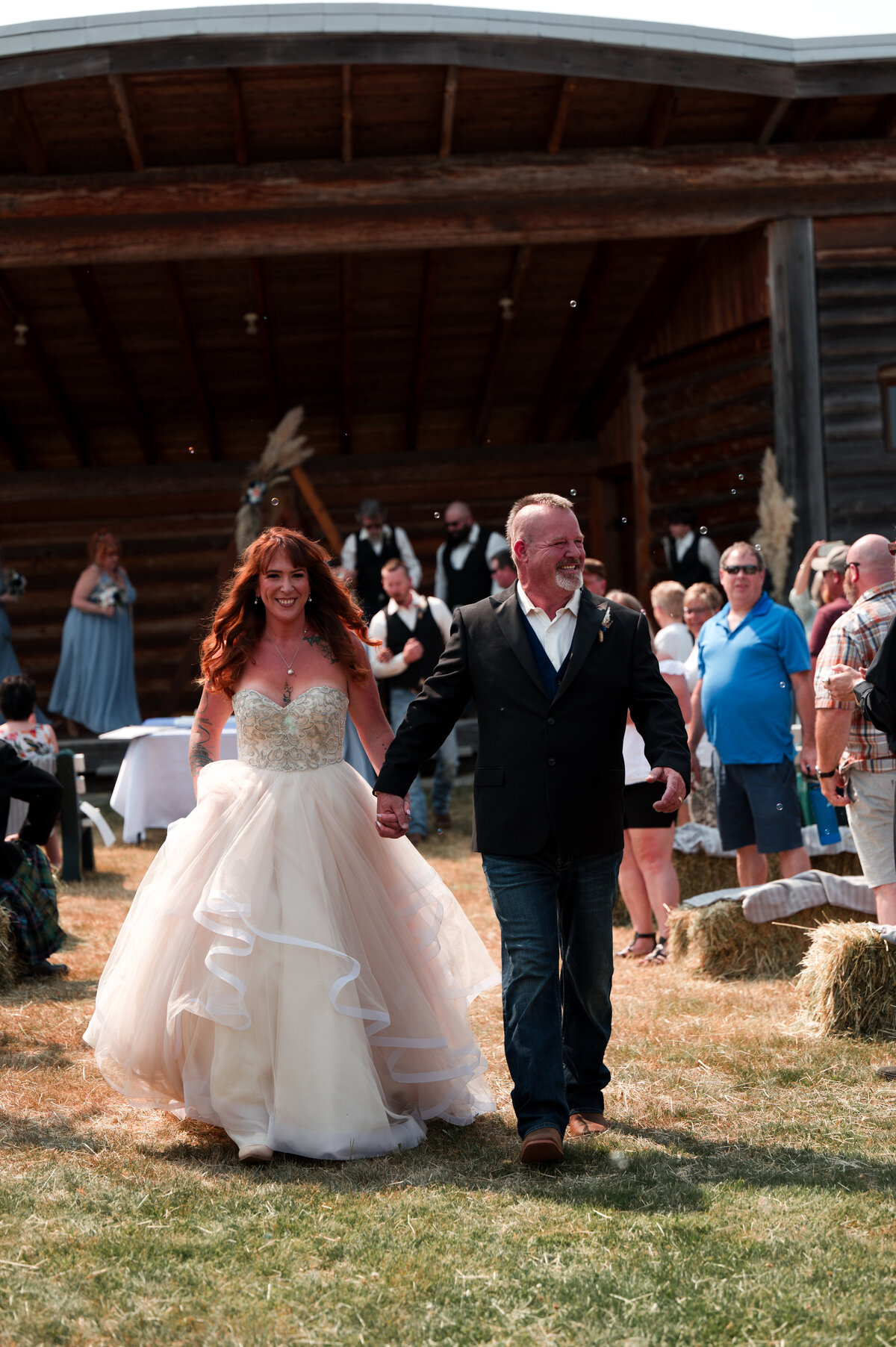 Bride and groom walk down holding hands at Coombs County Fairgrounds wedding on Vancouver Island, British Columbia