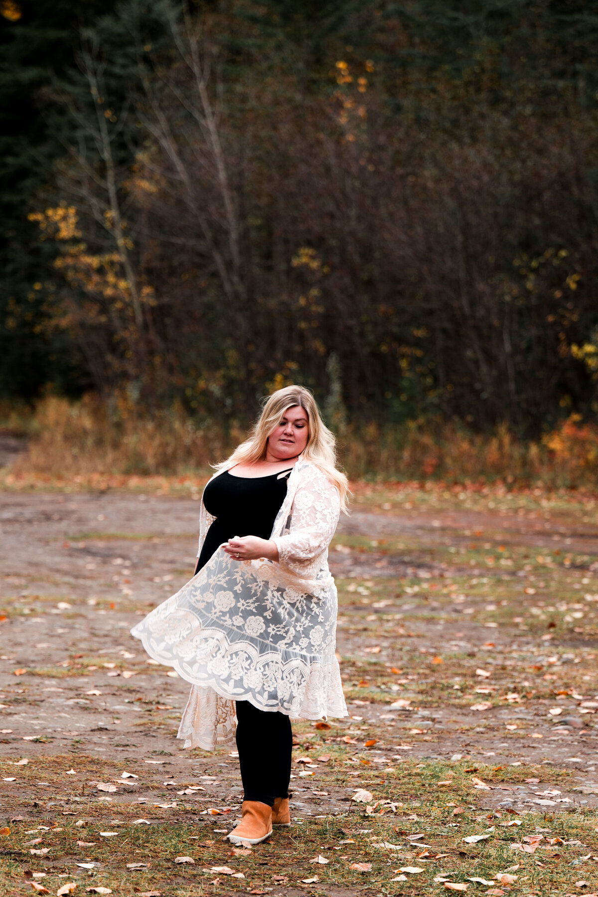 woman spins in a field with white cardigan