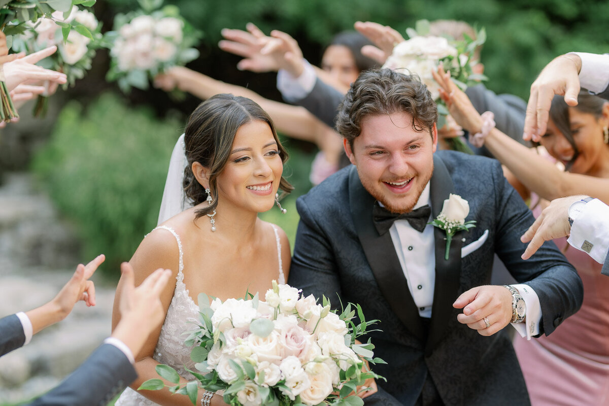 candid shot of bride and groom walking down the aisle as guests show excitement